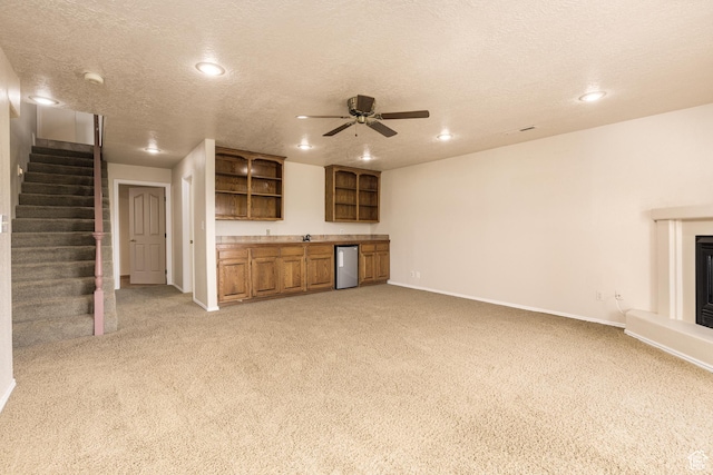 unfurnished living room featuring light carpet, wet bar, baseboards, recessed lighting, and stairway