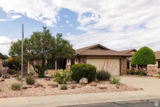 single story home with brick siding, a garage, concrete driveway, and a tile roof