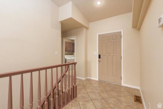 foyer with washer / clothes dryer, light tile patterned flooring, recessed lighting, and baseboards