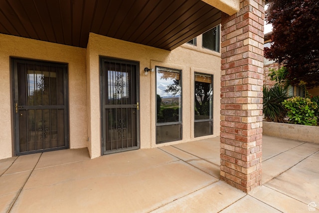 property entrance featuring stucco siding and covered porch