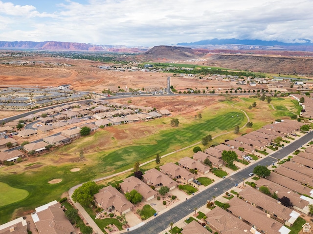 aerial view of property and surrounding area featuring nearby suburban area, a mountain backdrop, and a golf club