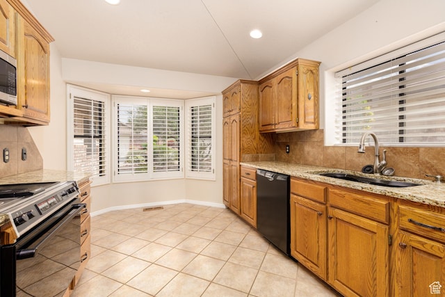 kitchen featuring dishwasher, range with electric cooktop, a sink, decorative backsplash, and light stone countertops