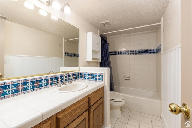 full bath featuring tile patterned flooring, toilet, shower / bath combo, wainscoting, and vanity