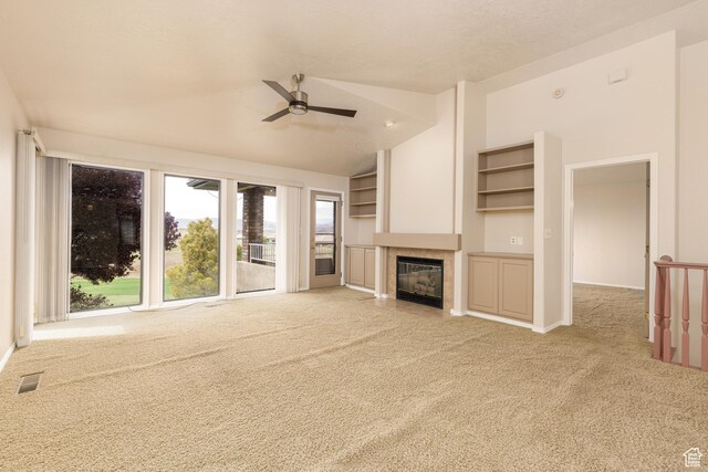 unfurnished living room featuring carpet, ceiling fan, a fireplace, and vaulted ceiling