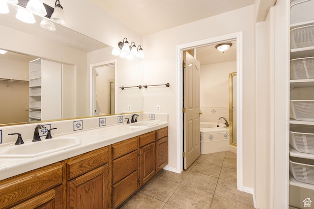 full bath with a spacious closet, tile patterned flooring, double vanity, and a tub