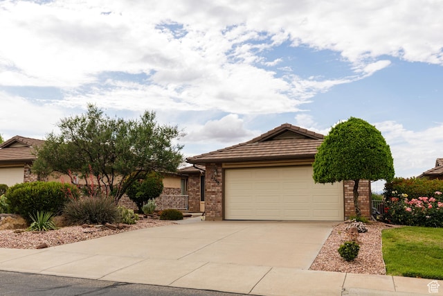 view of front of home with a tiled roof, concrete driveway, brick siding, and a garage