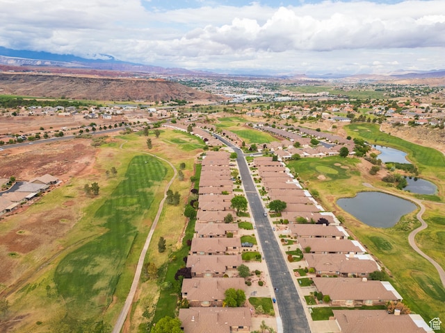 aerial overview of property's location with nearby suburban area, a water and mountain view, and a local golf course