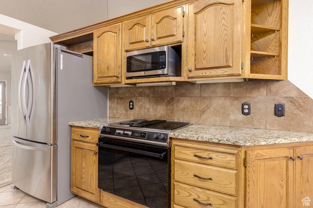 kitchen featuring appliances with stainless steel finishes, tasteful backsplash, and light stone countertops