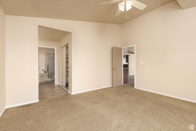 unfurnished room featuring carpet, ceiling fan, baseboards, and vaulted ceiling