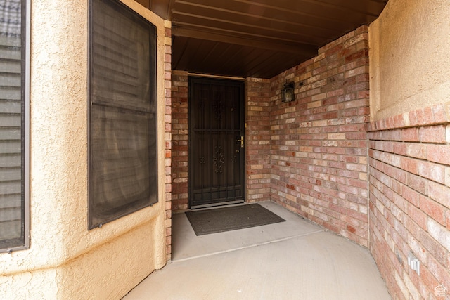 doorway to property featuring brick siding