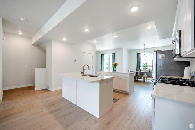 983 W 540 S, American Fork, UT 84003 - kitchen with a sink, an island with sink, stainless steel microwave, light wood-style floors, and recessed lighting