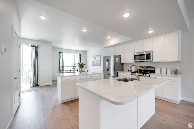 983 W 540 S, American Fork, UT 84003 - kitchen with appliances with stainless steel finishes, an island with sink, a sink, baseboards, and light wood-type flooring