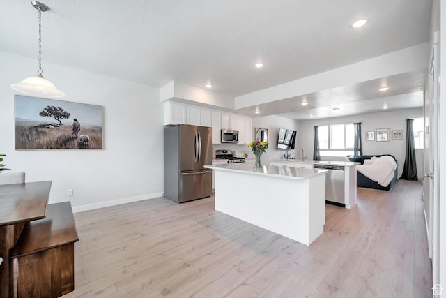 983 W 540 S, American Fork, UT 84003 - kitchen featuring stainless steel appliances, light countertops, light wood finished floors, white cabinetry, and a peninsula