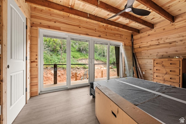 bedroom featuring wooden ceiling, wood walls, beam ceiling, multiple windows, and light wood finished floors