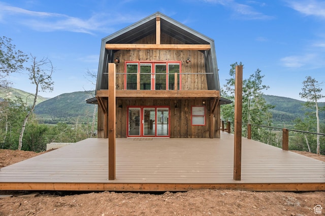back of property with a deck with mountain view
