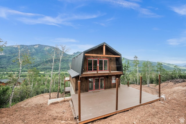 rear view of house with a gambrel roof, metal roof, and a deck with mountain view