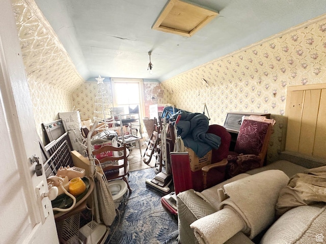 bonus room with wallpapered walls, attic access, and lofted ceiling