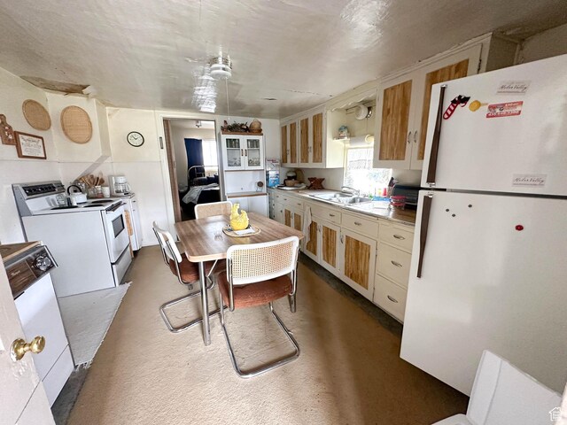 kitchen featuring white appliances, a sink, and light countertops