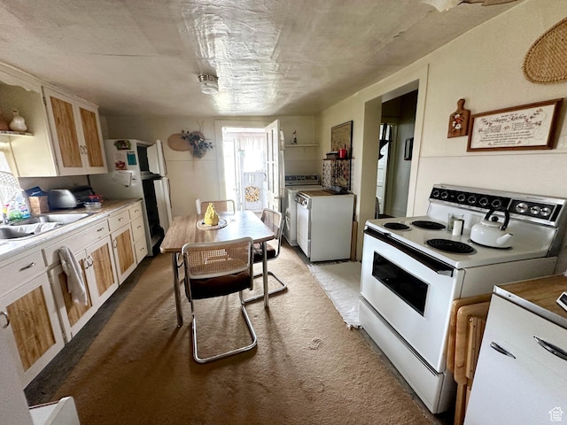 kitchen with white range with electric stovetop, carpet floors, a sink, and washing machine and dryer