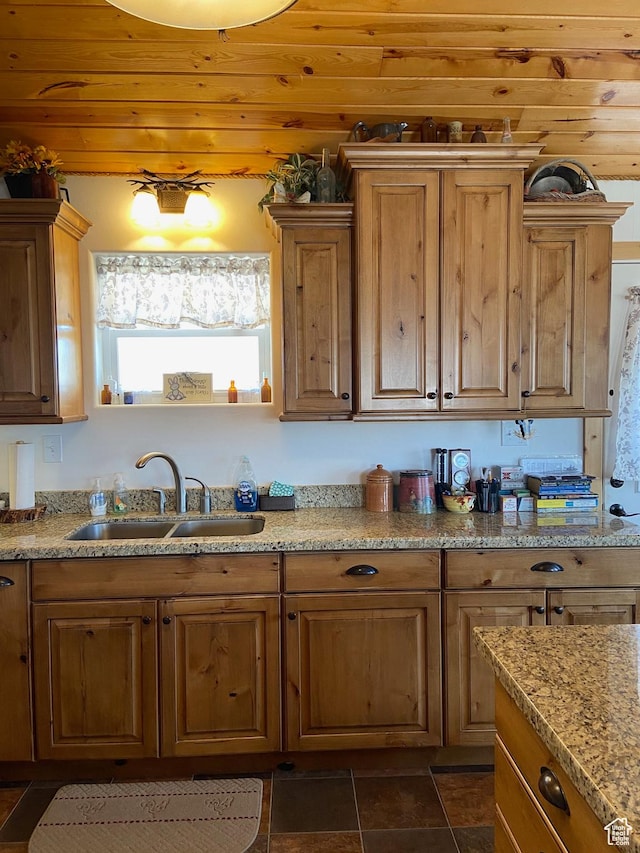 kitchen with a sink, light stone countertops, and wood ceiling