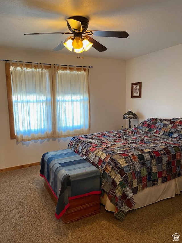 carpeted bedroom with multiple windows, a ceiling fan, and baseboards