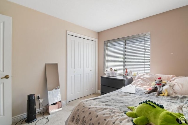 bedroom featuring baseboards, light carpet, and a closet