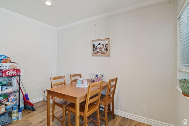 dining space with light wood finished floors, crown molding, baseboards, and recessed lighting