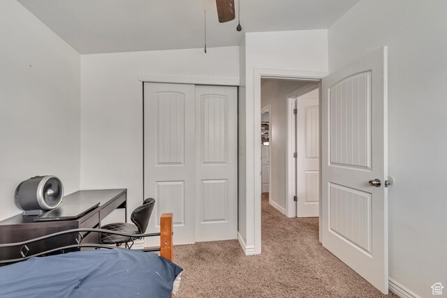 carpeted bedroom featuring a closet, baseboards, and a ceiling fan