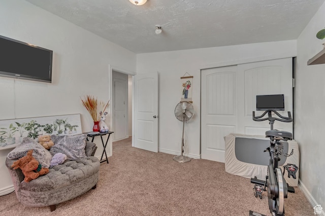 recreation room with carpet, baseboards, and a textured ceiling