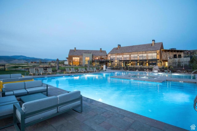 community pool with an outdoor hangout area, a community hot tub, and a patio area