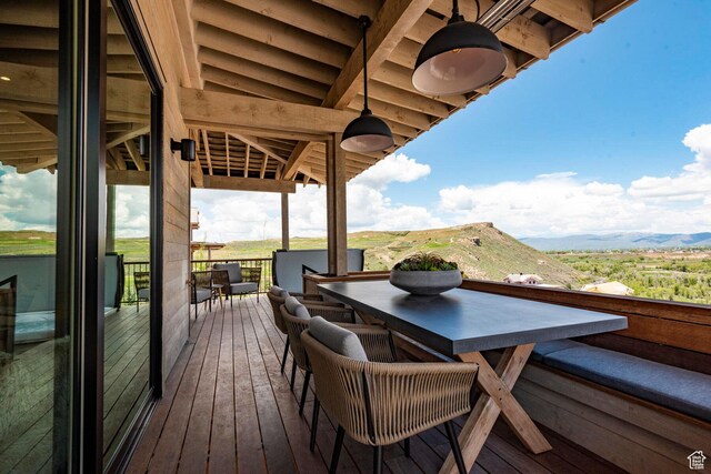 wooden deck with outdoor dining area and a mountain view