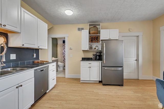 21 E Angelo Ave S, South Salt Lake, UT 84115 - kitchen featuring stainless steel appliances, white cabinetry, a sink, and light wood-style flooring