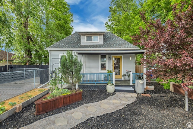 21 E Angelo Ave S, South Salt Lake, UT 84115 - bungalow with a shingled roof, covered porch, a garden, and fence