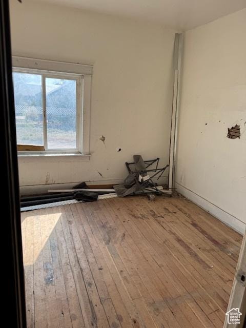unfurnished room with hardwood / wood-style flooring
