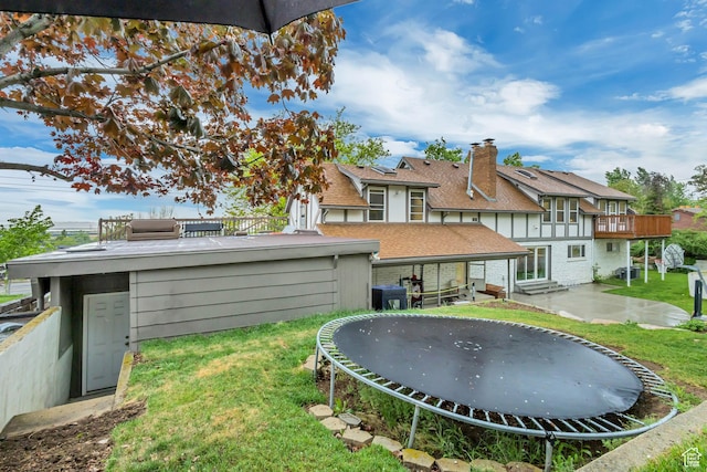 1343 S 200 E, Farmington, UT 84025 - rear view of house featuring a trampoline, brick siding, a yard, and a patio