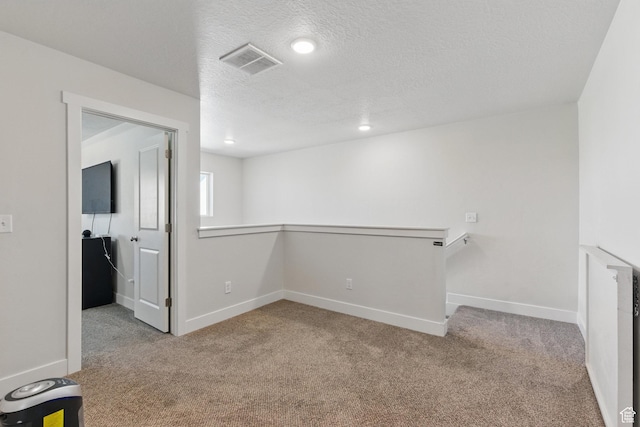 below grade area featuring carpet flooring, baseboards, a textured ceiling, and recessed lighting