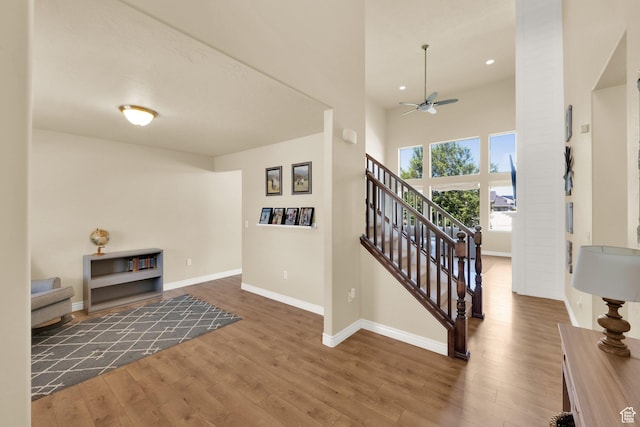 entrance foyer featuring a ceiling fan, wood finished floors, baseboards, stairs, and recessed lighting