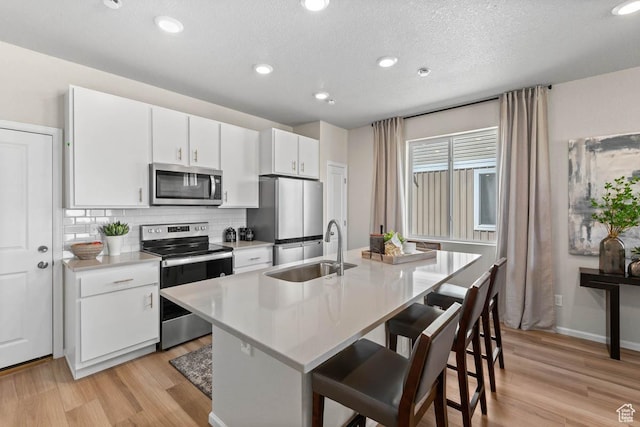 351 N Riverside Dr Unit 978, Saratoga Springs, UT 84045 - kitchen featuring appliances with stainless steel finishes, a sink, light wood-style flooring, light countertops, and recessed lighting