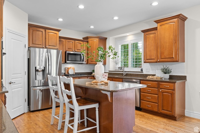 512 Glendon Way, Pleasant Grove, UT 84062 - kitchen with appliances with stainless steel finishes, a center island, light wood-style flooring, brown cabinetry, and recessed lighting