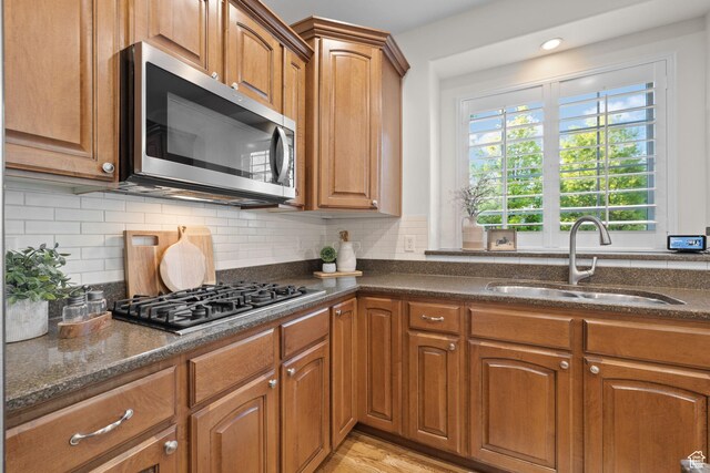 512 Glendon Way, Pleasant Grove, UT 84062 - kitchen with stainless steel appliances, a sink, dark stone countertops, and brown cabinets