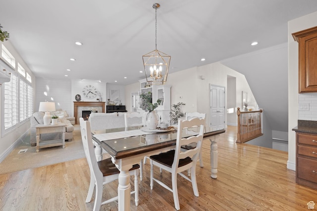 512 Glendon Way, Pleasant Grove, UT 84062 - dining space with light wood-style flooring, a chandelier, recessed lighting, a lit fireplace, and baseboards
