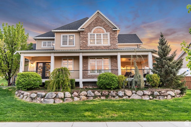 2032 E Pinecone Rd N, Eagle Mountain, UT 84005 - view of front of property featuring stone siding, a yard, a porch, and roof with shingles