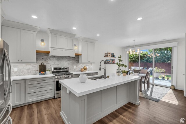 1492 S Carma St, Washington, UT 84780 - kitchen featuring appliances with stainless steel finishes, light countertops, decorative backsplash, a kitchen island with sink, and dark wood-style flooring