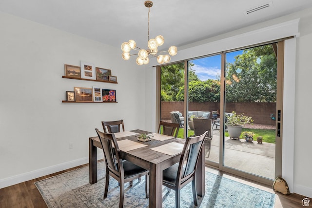 dining area featuring a chandelier, baseboards, and wood finished floors