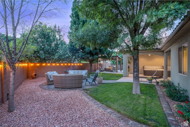 yard at dusk with outdoor lounge area and a patio