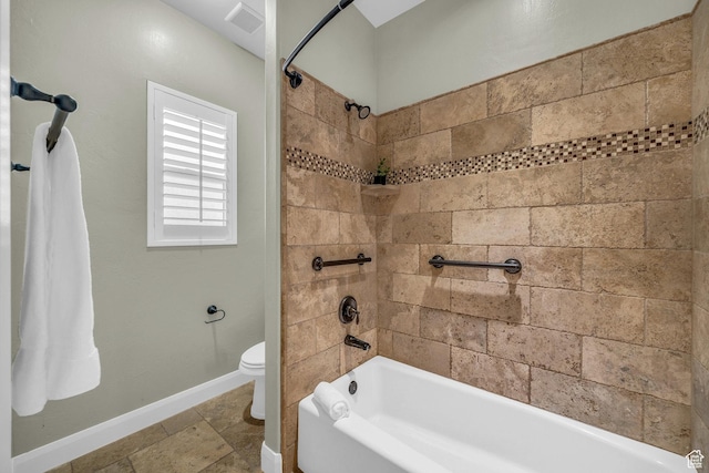 full bath with shower / bathtub combination, toilet, baseboards, and stone finish floors