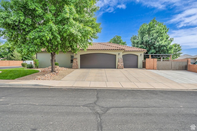 view of front of home featuring stucco siding, an attached garage, driveway, fence, and a tiled roof