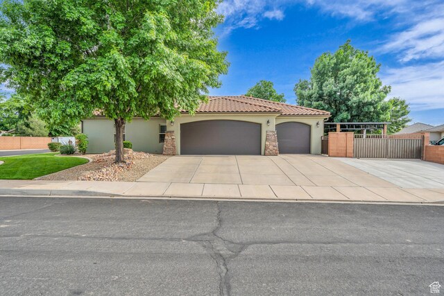1492 S Carma St, Washington, UT 84780 - view of front of property featuring stucco siding, a garage, driveway, a tiled roof, and stone siding