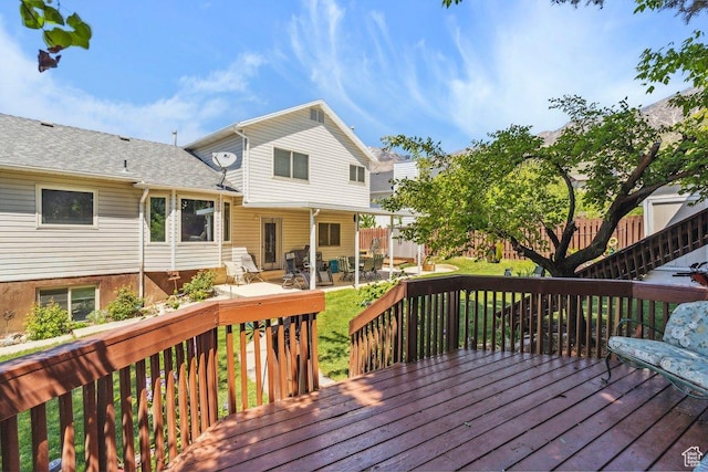 wooden terrace with a patio and a yard