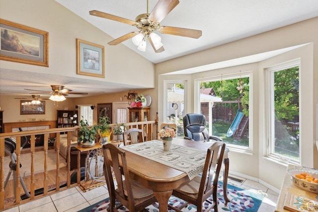 dining area with vaulted ceiling, ceiling fan, light tile patterned flooring, healthy amount of natural light, and baseboards